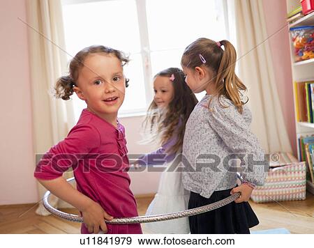 Stock Photo - Girls playing with hula hoop together. Fotosearch