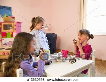 Girls playing with toy kitchen View Large Photo Image Stock Photo - Girls playing with toy kitchen. Fotosearch