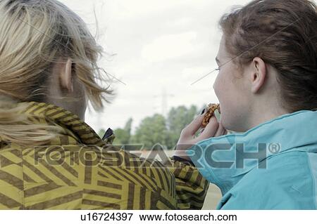 Girls sharing cookie outdoors View Large Photo Image Stock Photo - Girls sharing cookie outdoors. Fotosearch