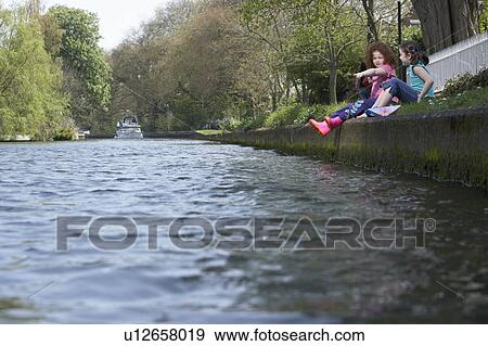 Girls sitting on riverbank together View Large Photo Image Stock Photo - Girls sitting on riverbank together. Fotosearch