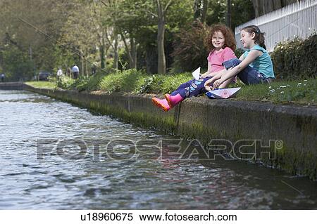 Girls sitting on riverbank together View Large Photo Image Stock Photography - Girls sitting on riverbank together. Fotosearch
