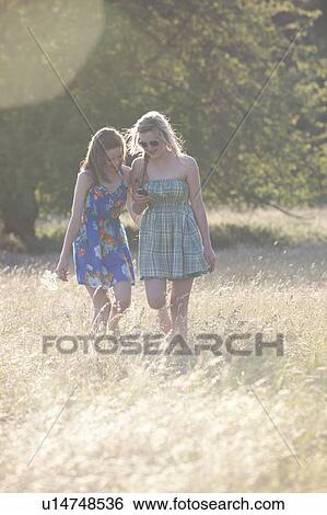 Girls using cell phone in field View Large Photo Image Stock Photograph - Girls using cell phone in field. Fotosearch