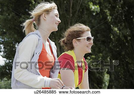 Girls walking in park together View Large Photo Image Stock Photography - Girls walking in park together. Fotosearch