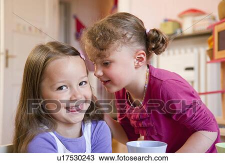 Girls whispering to each other View Large Photo Image Stock Image - Girls whispering to each other. Fotosearch