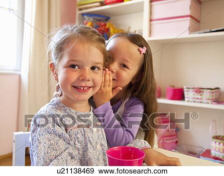 Girls whispering to each other View Large Photo Image Stock Photo - Girls whispering to each other. Fotosearch