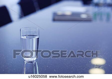 Glass of water on office desk View Large Photo Image Stock Photo - Glass of water on office desk. Fotosearch