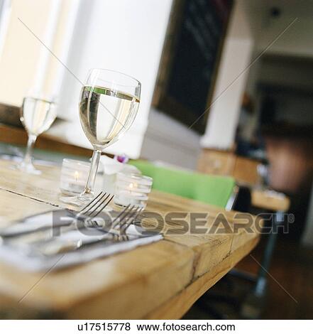 Glass of wine on set table View Large Photo Image Stock Photo - Glass of wine on set table. Fotosearch