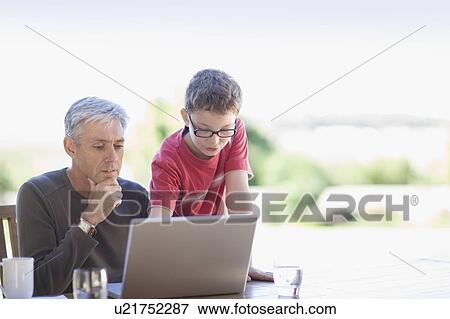 Grandfather and grandson using laptop View Large Photo Image Stock Photo - Grandfather and grandson using laptop. Fotosearch