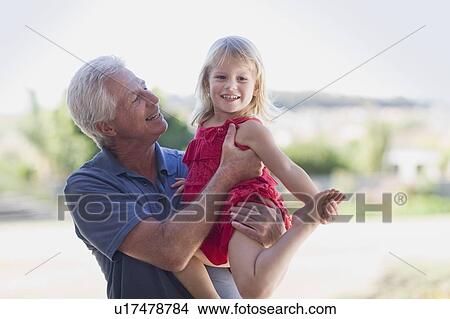 Grandfather holding granddaughter View Large Photo Image Picture - Grandfather holding granddaughter. Fotosearch