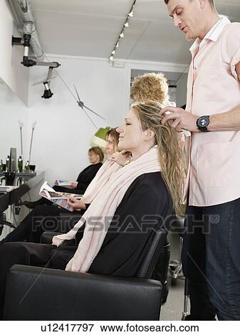 Stock Photo - Hairdresser examining woman’s hair. Fotosearch