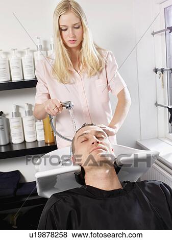 Stock Photo - Hairdresser washing man’s hair. Fotosearch