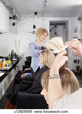 Stock Photograph - Hairdressers at work in salon. Fotosearch