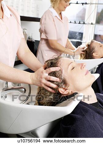 Picture - Hairdressers washing women’s hair. Fotosearch