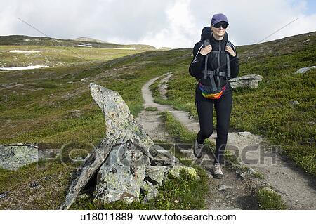 Stock Photo - Hiker walking on dirt road. Fotosearch