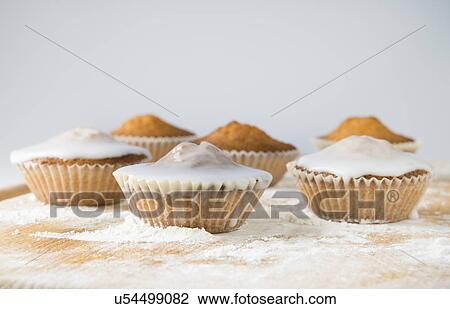 Iced cupcakes on cutting board View Large Photo Image Stock Image - Iced cupcakes on cutting board. Fotosearch