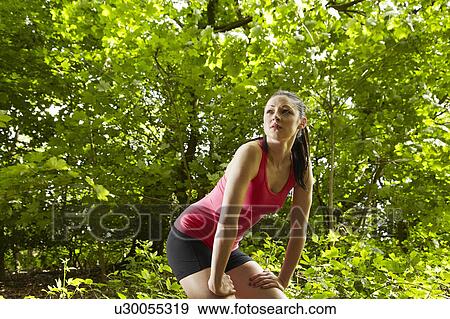 Stock Photo - Jogger resting in forest. Fotosearch