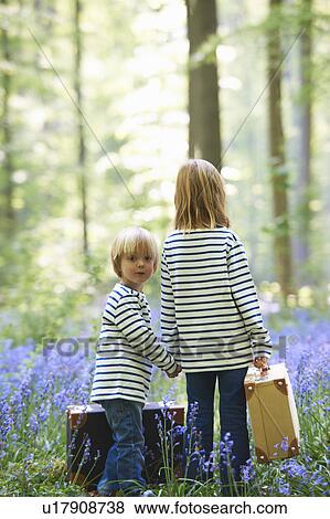 Stock Photo - Kids with luggage in field of flowers. Fotosearch