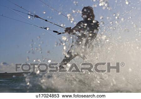 Stock Image - Kite surfer splashing in water. Fotosearch