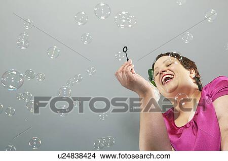 Large woman blowing bubbles View Large Photo Image Picture - Large woman blowing bubbles. Fotosearch