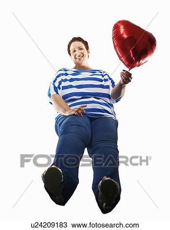 Large woman carrying heart balloon View Large Photo Image Stock Image - Large woman carrying heart balloon. Fotosearch