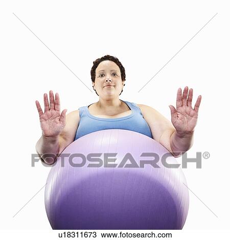 Stock Image - Large woman using exercise ball. Fotosearch