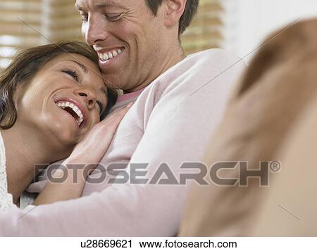 Laughing couple hugging View Large Photo Image Stock Image - Laughing couple hugging. Fotosearch