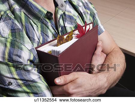 Picture - Leaves in businessman’s folder. Fotosearch