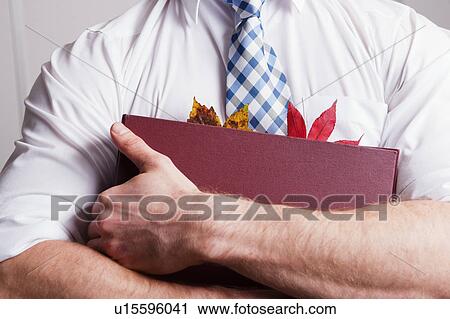 Stock Image - Leaves in businessman’s folder. Fotosearch