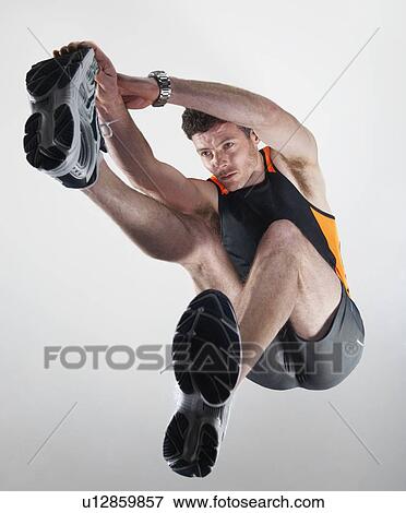 Low angle view of man stretching View Large Photo Image Stock Photo - Low angle view of man stretching. Fotosearch