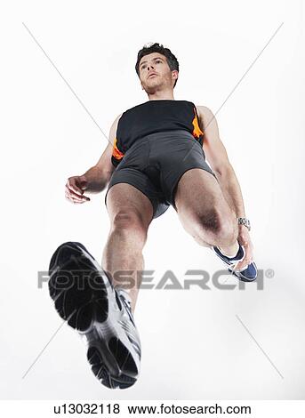Low angle view of man stretching View Large Photo Image Stock Photo - Low angle view of man stretching. Fotosearch