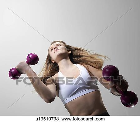 Low angle view of woman lifting weights View Large Photo Image Stock Photo - Low angle view of woman lifting weights. Fotosearch