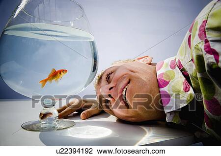 Man admiring goldfish in bowl View Large Photo Image Stock Image - Man admiring goldfish in bowl. Fotosearch