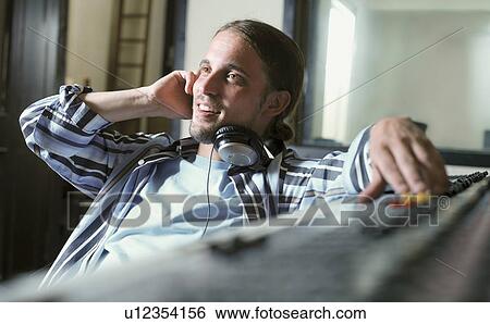 Stock Photograph - Man at control panel in recording studio. Fotosearch