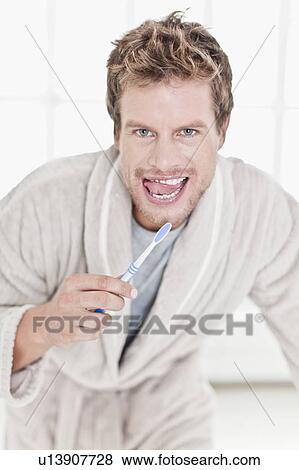 Stock Photo - Man brushing his teeth in bathroom. Fotosearch