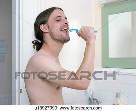 Man brushing his teeth in bathroom View Large Photo Image Stock Photo - Man brushing his teeth in bathroom. Fotosearch
