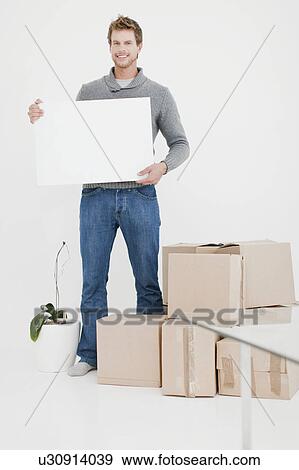 Man carrying boxes in new home View Large Photo Image Stock Photo - Man carrying boxes in new home. Fotosearch