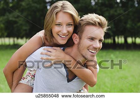 Man carrying girlfriend in field View Large Photo Image Stock Photo - Man carrying girlfriend in field . Fotosearch