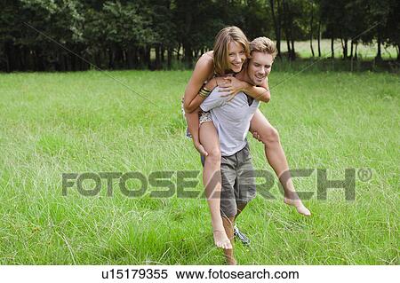 Man carrying girlfriend in field View Large Photo Image Stock Photography - Man carrying girlfriend in field. Fotosearch