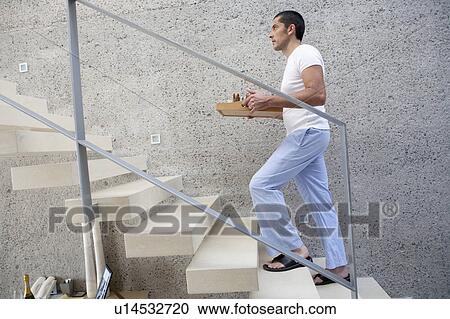 Man carrying tray of food up stairs View Large Photo Image Stock Image - Man carrying tray of food up stairs. Fotosearch