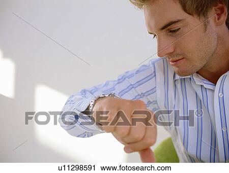Man checking his watch View Large Photo Image Stock Image - Man checking his watch. Fotosearch
