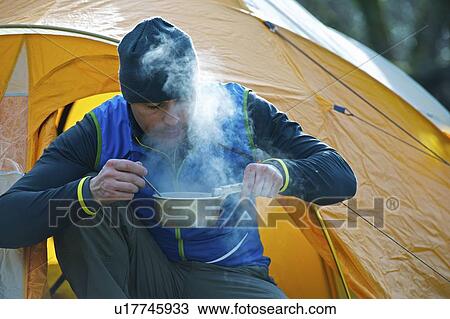Man cooking food by camping tent View Large Photo Image Stock Image - Man cooking food by camping tent. Fotosearch