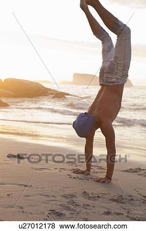 Man doing a handstand on beach View Large Photo Image Stock Photo - Man doing a handstand on beach. Fotosearch