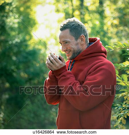 Man drinking cup of coffee in forest View Large Photo Image Picture - Man drinking cup of coffee in forest. Fotosearch
