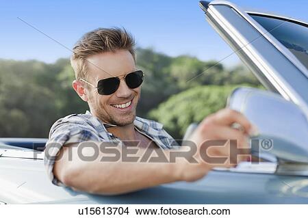 Picture - Man driving convertible. Fotosearch