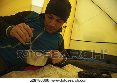 Man eating in camping tent View Large Photo Image Stock Photograph - Man eating in camping tent. Fotosearch