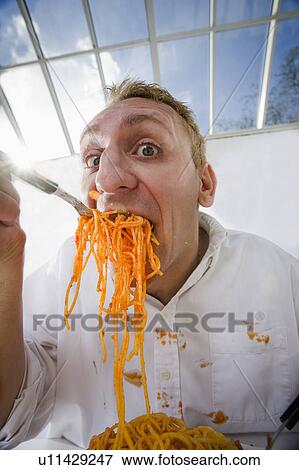 Stock Photo - Man eating plate of spaghetti. Fotosearch