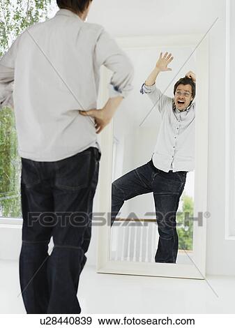 Man examining his grimacing reflection View Large Photo Image Stock Photo - Man examining his grimacing reflection. Fotosearch