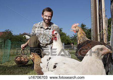 Man feeding chickens outdoors View Large Photo Image Stock Image - Man feeding chickens outdoors. Fotosearch