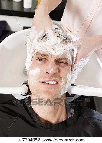 Stock Image - Man having hair washed in salon. Fotosearch