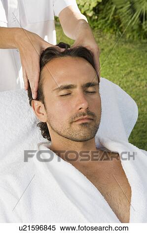 Stock Photography - Man having scalp massage outdoors. Fotosearch